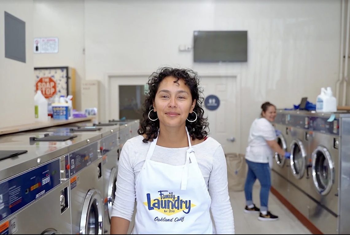 A Family Laundry team member in front of the commercial washers