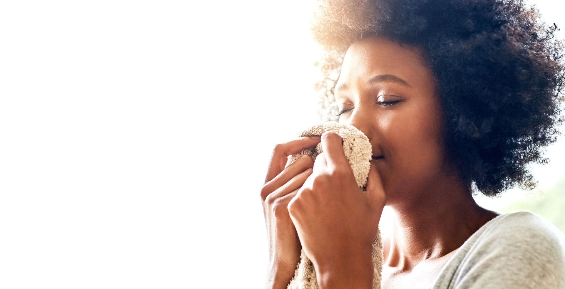 A woman smelling freshly cleaned laundry