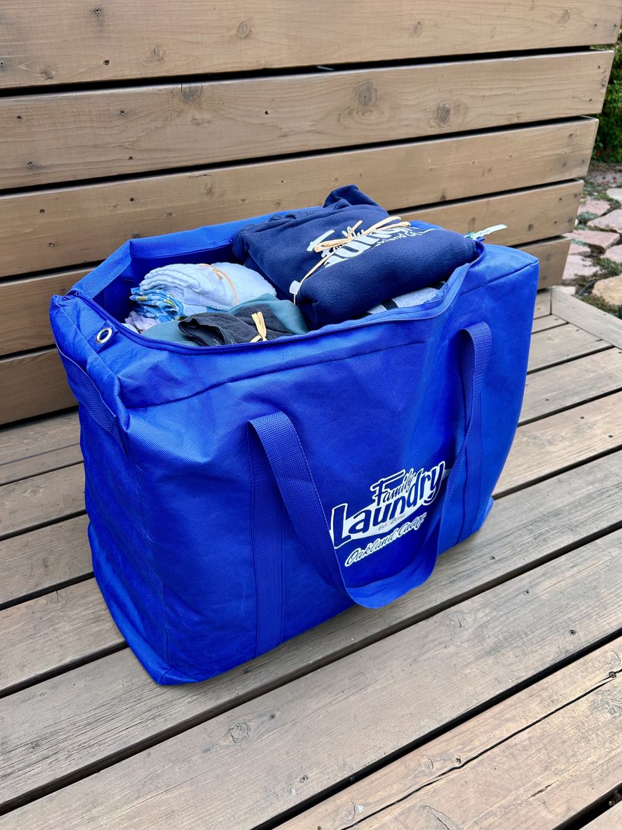A Family Laundry bag of folded, bundled laundry delivered to a doorstep