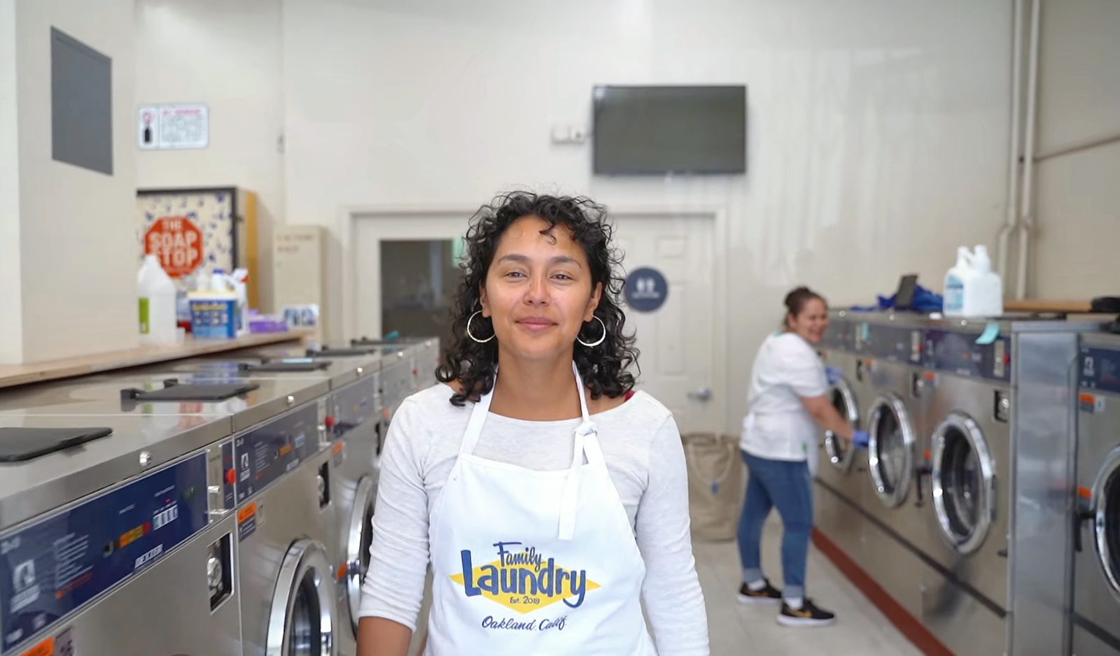 A Family Laundry team member in an apron inside the laundromat