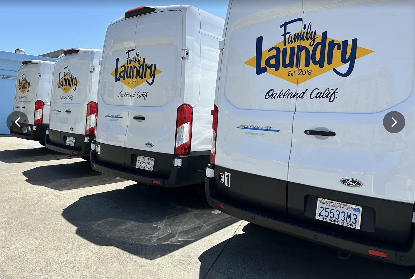 Family Laundry electric Ford E-Transit vans parked in a row